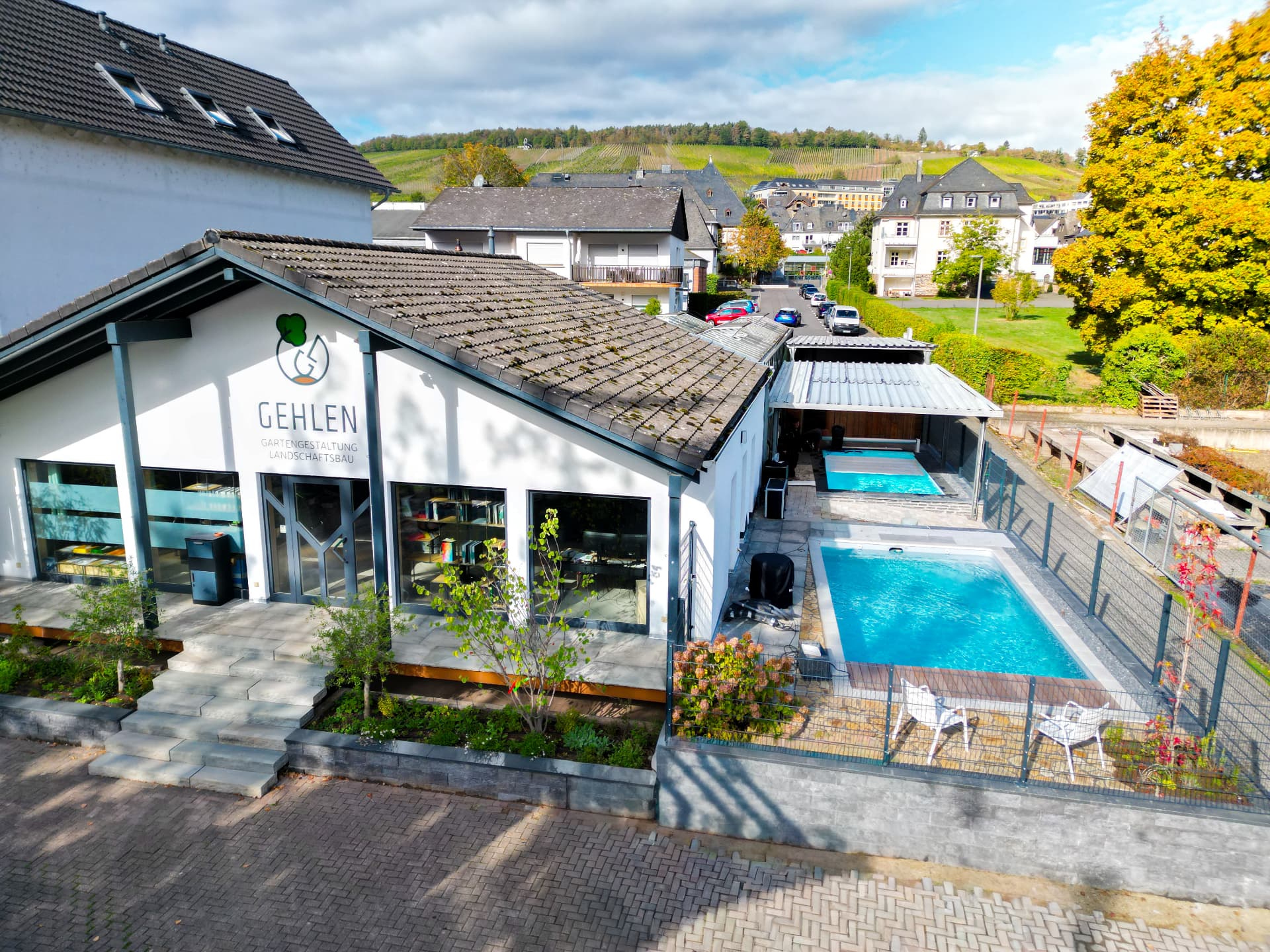 Firmensitz und Pool-Ausstellung von Gehlen in Bernkastel-Kues mit zwei Desjoyaux-Pools und den Mosel-Weinbergen im Hintergrund